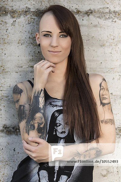Junge Frau mit vielen Tattoos lächelt  Portrait