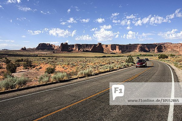 Road with cars  Arches Science Drive  Courthouse Towers behind  Arches National Park  Utah  USA  North America
