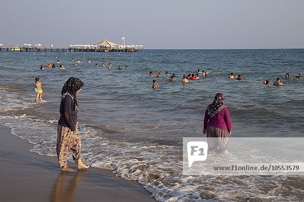 Türkinnen gehen mit Kleidung im Meer baden  Side-Sorgun  Side Belediyesi  türkische Riviera  Antalya  Türkei  Asien