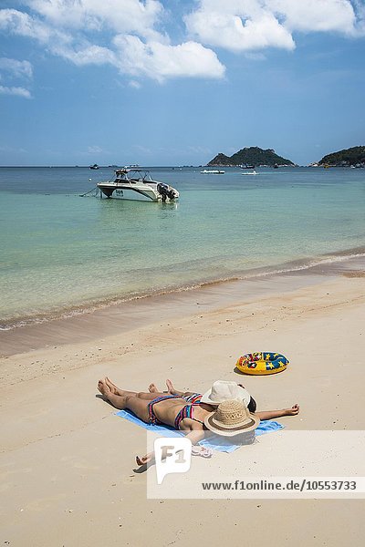 Mutter und Kind liegen am Sandstrand  Sairee Beach  türkises Meer  Insel Koh Tao  Golf von Thailand  Thailand  Asien