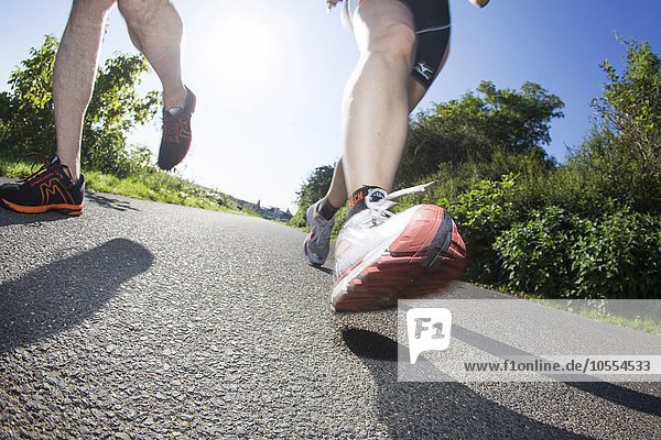 Legs  jogging shoes  joggers on asphalt track  Germany  Europe