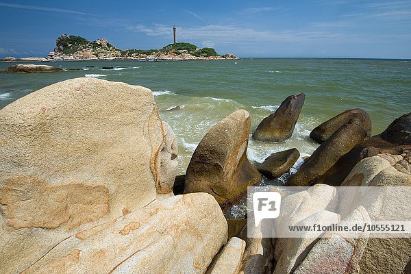 Sandstones in the surf  in the back highest Lighthouse of Vietnam  Phan Thiet  Ke Ga  Vietnam  Asia