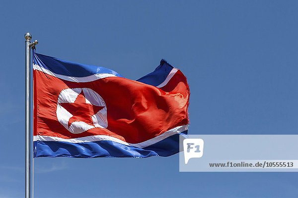 Nord-koreanische Flagge,  Nordkorea-Fahne weht im Wind,  blauer Himmel