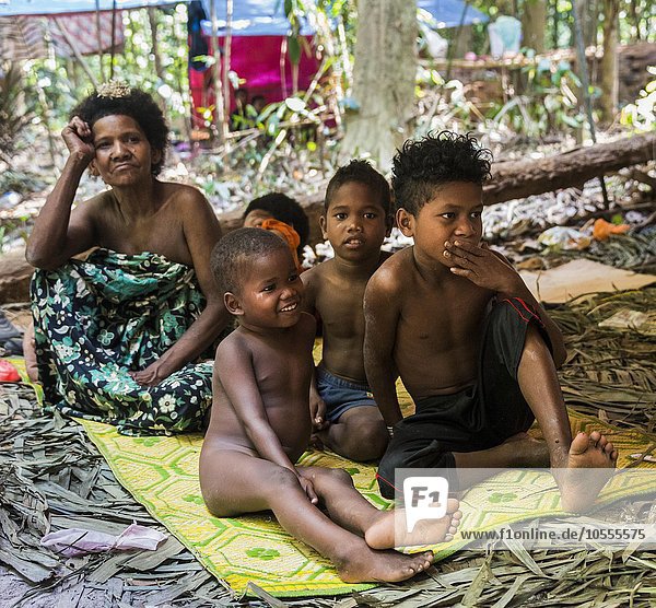 Frau und Kinder  Ureinwohner Orang Asil  sitzen am Boden im Dschungel  indigenes Volk  tropischer Regenwald  Nationalpark Taman Negara  Malaysia  Asien