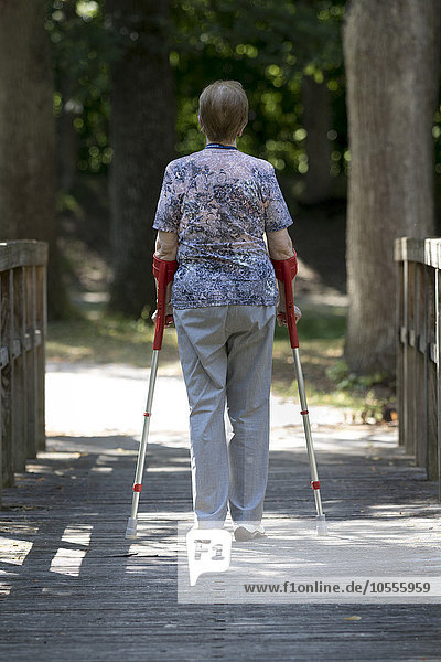 Elderly woman walking with crutches  Germany  Europe