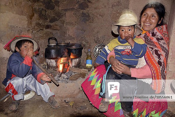 Indios  Frau in Tracht mit zwei Kindern beim Kochen über Holzfeuer in der Küche  bei Cusco  Peru  Südamerika