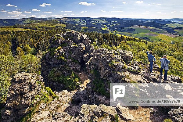 Zwei Männer blicken vom Gipfel der Bruchhausener Steine in die weite Landschaft  Olsberg  Sauerland  Nordrhein-Westfalen  Deutschland  Europa
