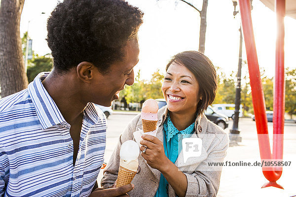 Lächelndes Paar isst Eis im Park