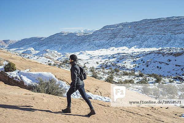 Kaukasische Frau beim Wandern auf einem abgelegenen Berghang