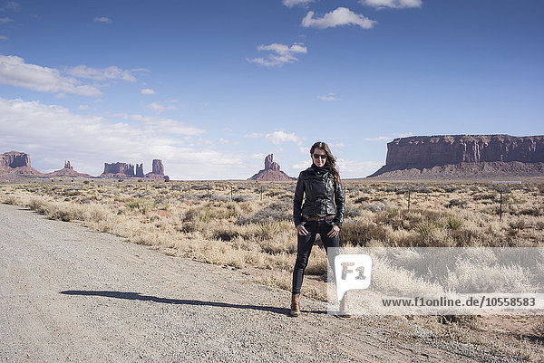 Caucasian woman standing on desert dirt road