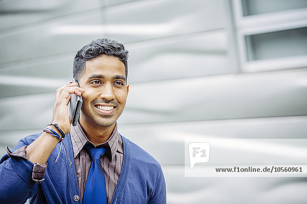 Indian businessman talking on cell phone outdoors
