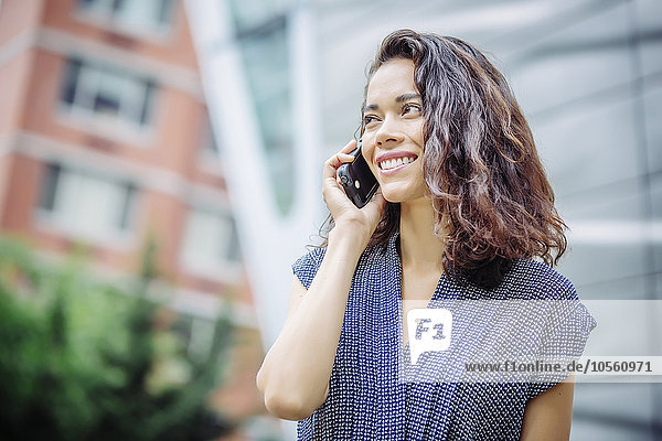 Mixed race businesswoman talking on cell phone outdoors