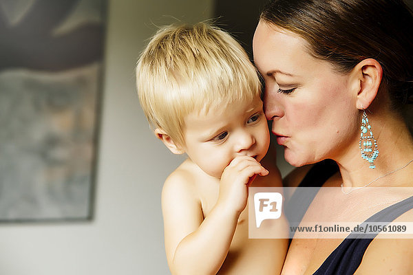 Close up of mother holding son in living room