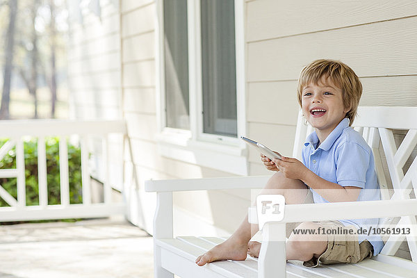 Caucasian boy using digital tablet on patio