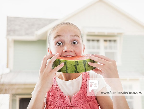 Kaukasisches Mädchen isst Wassermelone im Freien