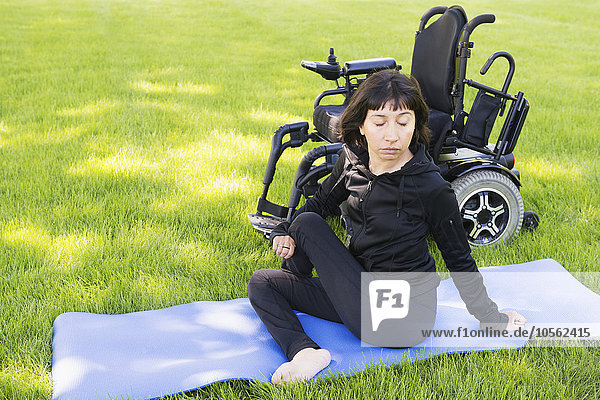 Behinderte Frau streckt ihre Beine im Park