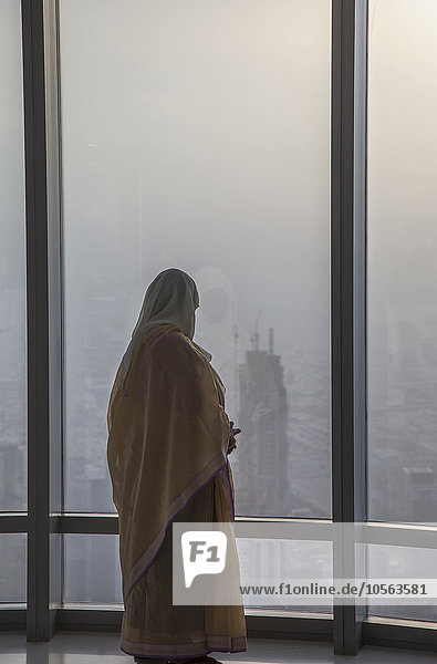 Asiatische Frau am Fenster  die das Stadtbild von Dubai bewundert  Emirat Dubai  Vereinigte Arabische Emirate