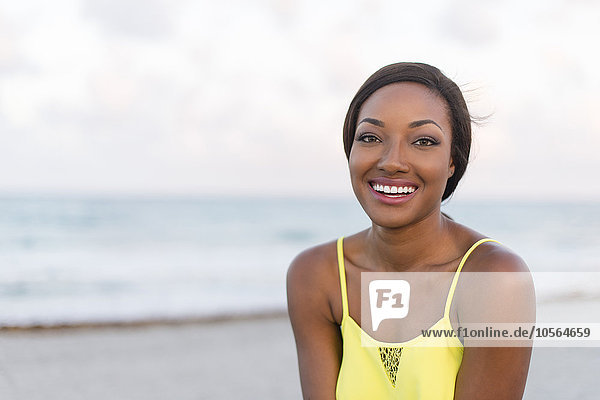 Schwarze Frau lächelnd am Strand