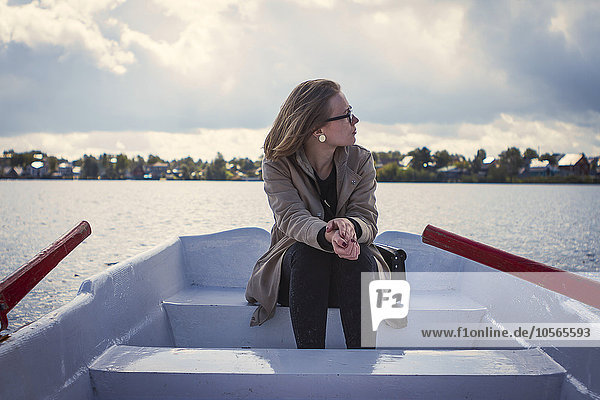 Kaukasische Frau sitzt in einem Ruderboot