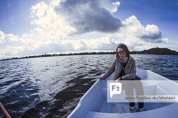 Kaukasische Frau sitzt auf einem Ruderboot