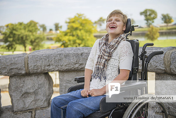 Querschnittsgelähmte Frau lacht im Rollstuhl
