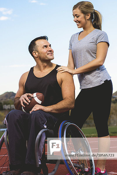 Querschnittsgelähmter Sportler im Rollstuhl mit Freundin