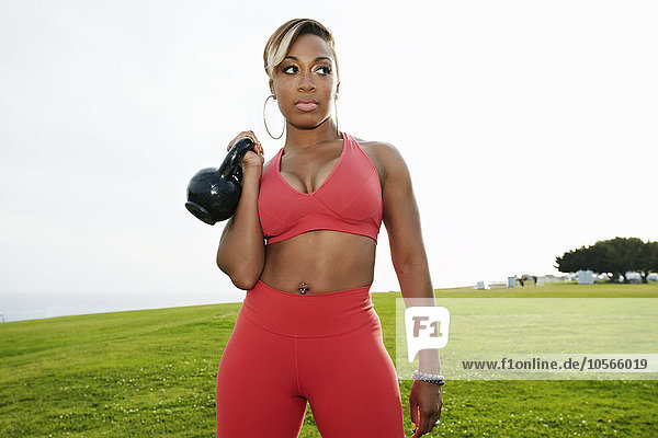 Schwarze Frau hebt Gewichte im Feld