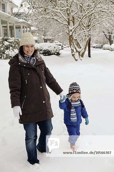 Caucasian mother and son walking in snow