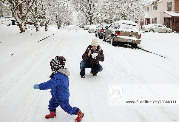 Caucasian mother and son playing in snow