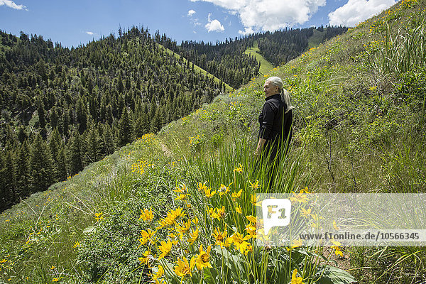 Kaukasische Frau  die auf einem abgelegenen Hügel spazieren geht