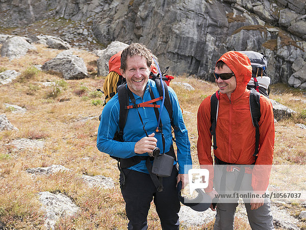 Caucasian hikers smiling on hillside