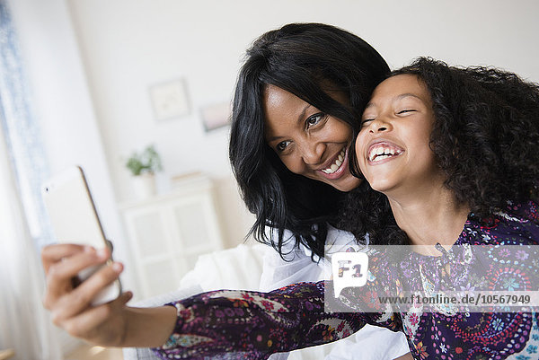 Mutter und Tochter nehmen Selfie mit Handy