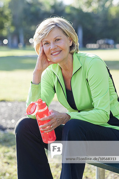 Caucasian woman drinking water bottle in park
