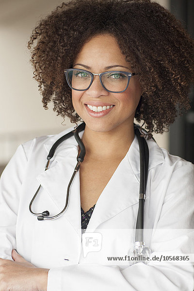 Mixed race doctor smiling with arms crossed