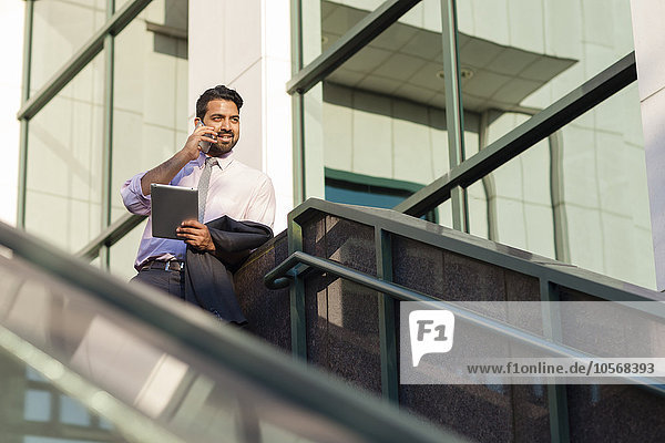 Indian businessman talking on cell phone on steps