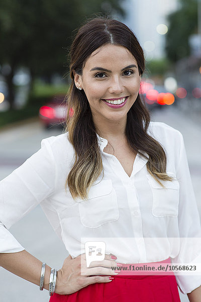 Hispanische Geschäftsfrau lächelnd im Freien