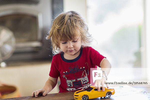 Caucasian boy playing with toy car