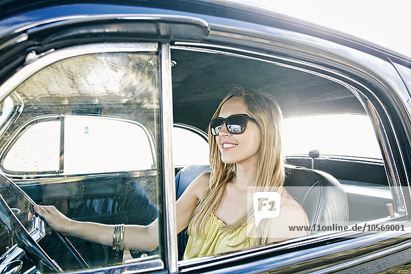 Caucasian woman driving vintage car