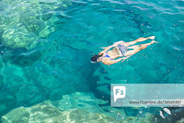 Hispanische Frau schwimmt im Meer
