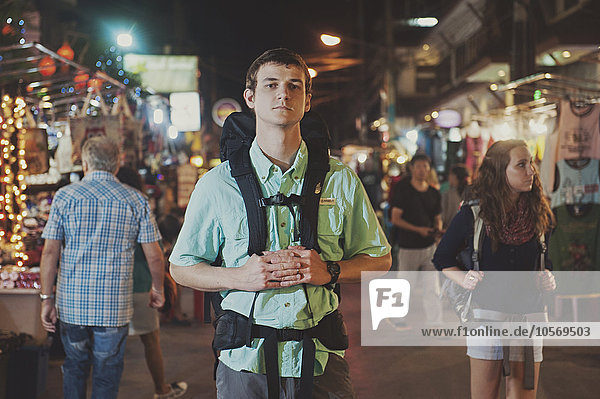 Caucasian tourist standing in market at night