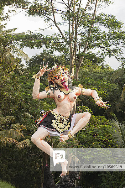 Statue of dancing deity in lush forest