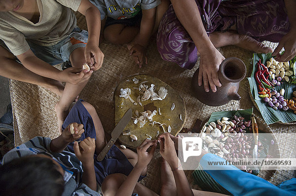 Asiatische Familie isst auf gewebter Matte