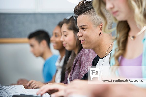 Row of teenage high school students in computer class