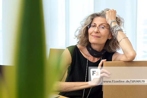 Porträt einer älteren Geschäftsfrau  die sich auf einem Bürostuhl entspannt