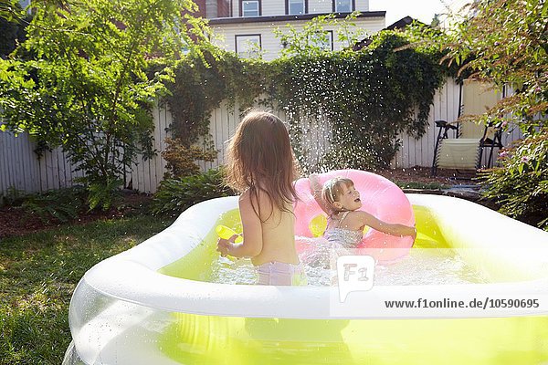 Mädchen haben Spaß im aufblasbaren Pool