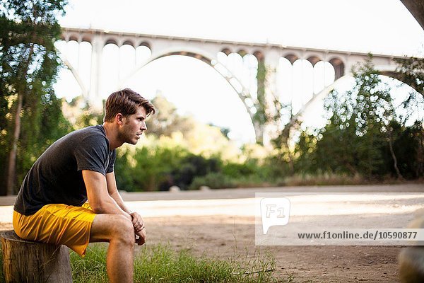 Jogger macht Pause  Bogenbrücke im Hintergrund  Arroyo Seco Park  Pasadena  Kalifornien  USA