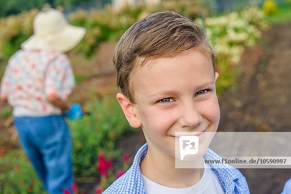 Portrait of boy in front of great grandmother on farm