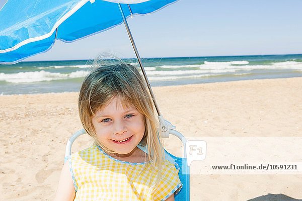 Porträt eines Mädchens im Sonnenschirm am Strand