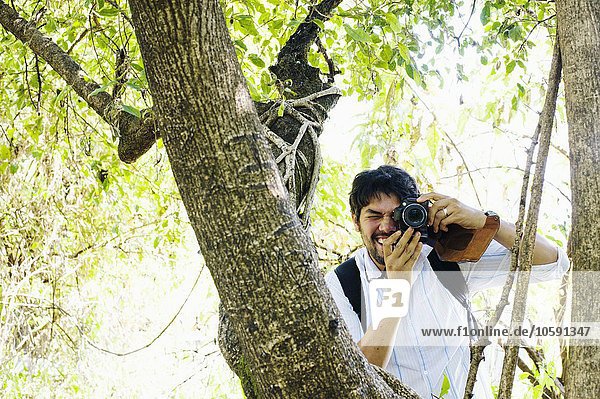 Mid adult man photographing from tree  Zambia