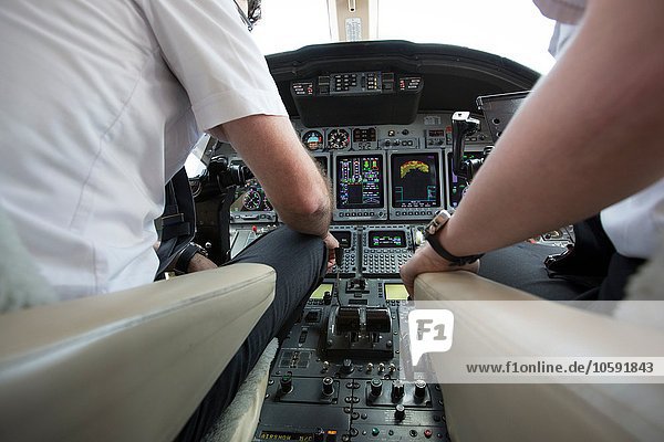 Männliche und weibliche Piloten im Cockpit des Privatjets